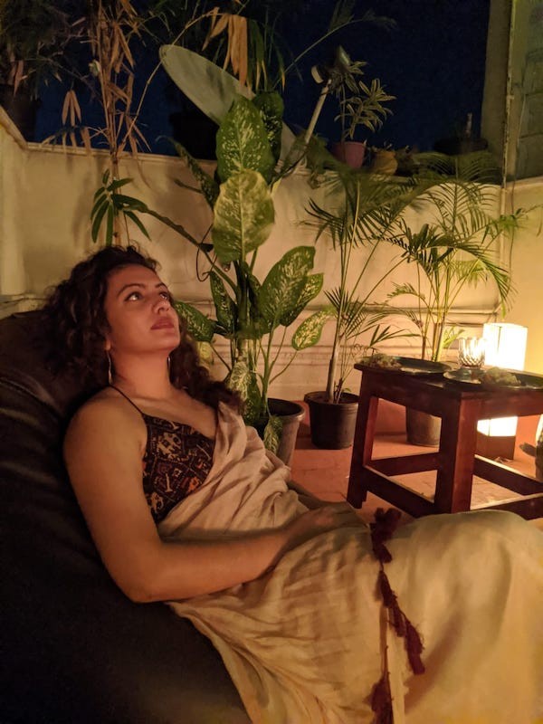 picture-of-deepti-sitting-on-couch-with-plants-behind-her